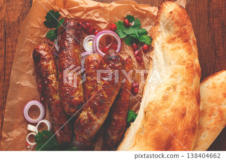 fried kupaty on parchment, with red onion and pomegranate, kupaty, Georgian cuisine, fried kupaty on parchment, with red onion and pomegranate, kupaty, Georgian cuisine, 138404662