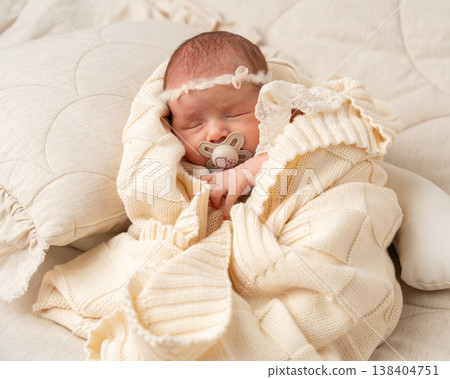 Peaceful newborn baby sleeping in a cozy knitted blanket. Soft natural light, neutral tones and minimalist composition highlighting innocence, warmth and family care Peaceful newborn baby sleeping in a cozy knitted blanket. Soft natural light, neutral tones and minimalist composition highlighting innocence, warmth and family care 138404751