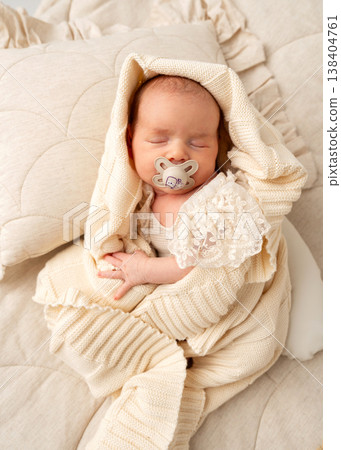 Portrait of a sleeping newborn baby wrapped in soft knitted blanket. Minimal composition, warm tones and gentle light create a calm and cozy newborn lifestyle image Portrait of a sleeping newborn baby wrapped in soft knitted blanket. Minimal composition, warm tones and gentle light create a calm and cozy newborn lifestyle image 138404761