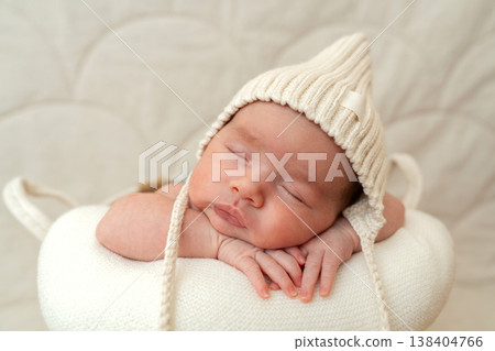 Close portrait of sleeping newborn wearing knit bonnet. Soft neutral tones and natural light create warm motherhood and family bonding concept Close portrait of sleeping newborn wearing knit bonnet. Soft neutral tones and natural light create warm motherhood and family bonding concept 138404766