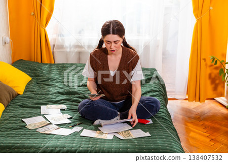 Caucasian woman calculating monthly expenses and preparing investment strategies for financial stability. concept of financial literacy and economic awareness. Top view Caucasian woman calculating monthly expenses and preparing investment strategies for financial stability. concept of financial literacy and economic awareness. Top view 138407532