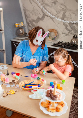 Caucasian mother and daughter creating handmade Easter eggs, focusing on traditions and meaningful family time. Concept of heritage, bonding, love, childhood and holiday preparation. Caucasian mother and daughter creating handmade Easter eggs, focusing on traditions and meaningful family time. Concept of heritage, bonding, love, childhood and holiday preparation. 138407537
