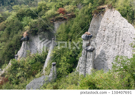 Stone capped earth columns at the Pyramids of Zone rise near Lake Iseo with white spires 138407691