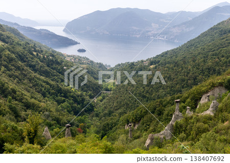 Zone Rock Pyramids above Lake Iseo show pale earth towers with dark capstones green Lombardy slope 138407692