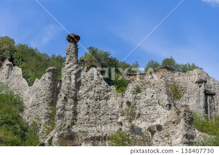 Pyramids of Zone near Lake Iseo show white sediment cliffs slender capped pillars under bright sky 138407730