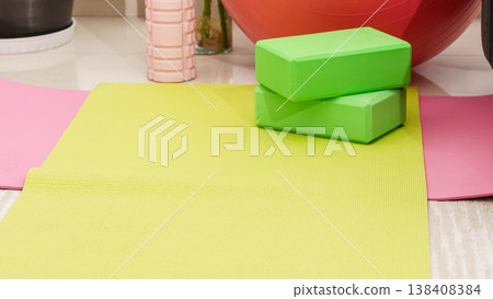 Green yoga blocks and white strap on green background. Yoga practice, relaxation and meditation concept. Top view with copy space. High quality photo Green yoga blocks and white strap on green background. Yoga practice, relaxation and meditation concept. Top view with copy space. High quality photo 138408384