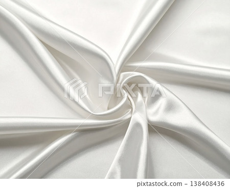 A close-up image of elegantly draped, lustrous white silk fabric. 138408436