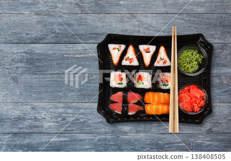 Japanese food delivery. Sushi and rolls top view with copy space on blue wood Japanese food delivery. Sushi and rolls top view with copy space on blue wood 138408505