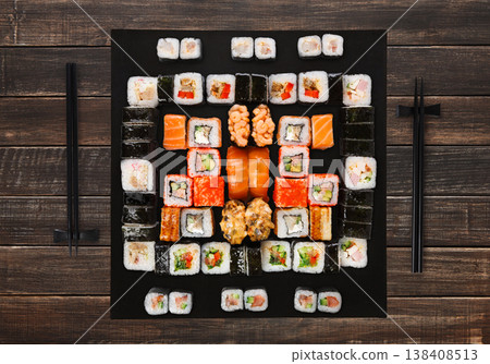 Japanese food restaurant delivery - sushi maki, unagi, gunkan and roll big party platter set on brown wood background, above view Japanese food restaurant delivery - sushi maki, unagi, gunkan and roll big party platter set on brown wood background, above view 138408513