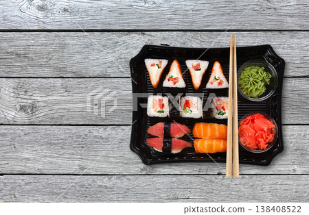 Japanese food delivery. Sushi and rolls top view with copy space on gray wood 138408522