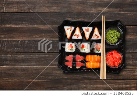 Japanese food delivery. Sushi and rolls top view with copy space on brown wood 138408523
