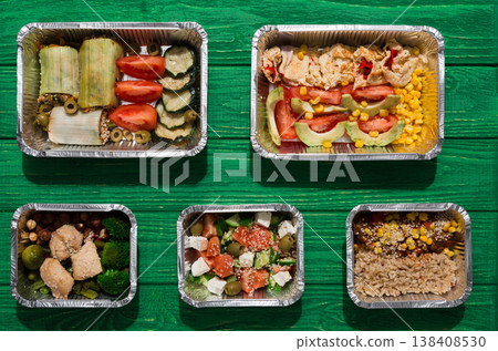 Healthy restaurant food delivery. Take away of natural organic fitness nutrition for diet. Daily meals in foil boxes with copy space at green wood. Vegetables, meat and fruits. Healthy restaurant food delivery. Take away of natural organic fitness nutrition for diet. Daily meals in foil boxes with copy space at green wood. Vegetables, meat and fruits. 138408530