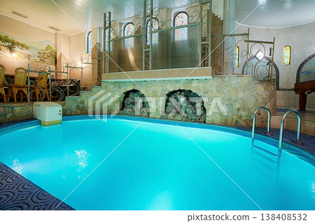 Blue swimming pool in modern spa interior. Resort and wellness. Blue clear water indoor pool in spa center. Healthcare and rest, relaxation concept. Blue swimming pool in modern spa interior. Resort and wellness. Blue clear water indoor pool in spa center. Healthcare and rest, relaxation concept. 138408532