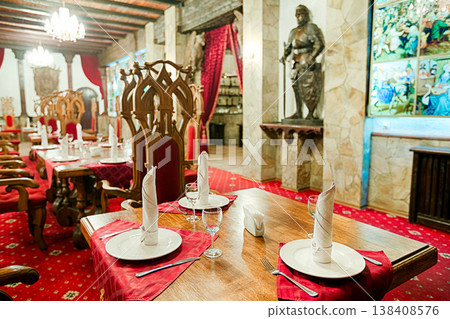 Restaurant interior styled as ancient medieval castle, palace. Red Thrones and tables. Festive british restaurant interior, catering, served banquet or wedding. Vintage, castle and palace interior. Restaurant interior styled as ancient medieval castle, palace. Red Thrones and tables. Festive british restaurant interior, catering, served banquet or wedding. Vintage, castle and palace interior. 138408576