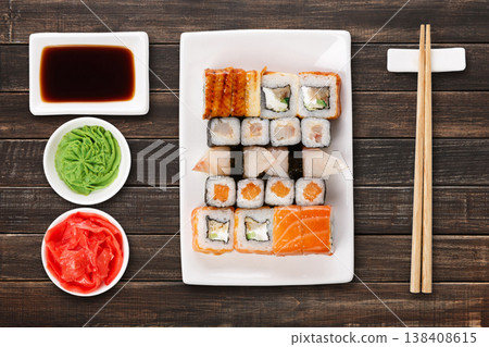 Japanese food restaurant delivery - sushi maki, unagi and roll platter set isolated on brown wood background, above view 138408615