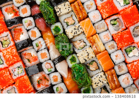 Sushi and rolls pattern background, japanese restaurant delivery top view. Salmon, unagi, california and other healthy meals Sushi and rolls pattern background, japanese restaurant delivery top view. Salmon, unagi, california and other healthy meals 138408618