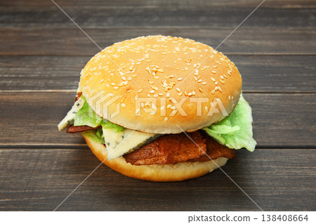 Classic american burger fast food. Big double burger at wood. Hamburger with fresh vegetables and meat. Burger with cheese, beef, tomato, lettuce. Cheeseburger at rustic wooden background. 138408664