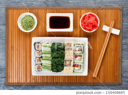 Japanese food restaurant delivery - sushi maki, unagi and roll platter set on mat on blue wood background, above view Japanese food restaurant delivery - sushi maki, unagi and roll platter set on mat on blue wood background, above view 138408665