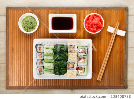 Japanese food restaurant delivery - sushi maki, unagi and roll platter set on mat on natural wooden background, above view Japanese food restaurant delivery - sushi maki, unagi and roll platter set on mat on natural wooden background, above view 138408788