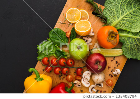 Cooking healthy vegetarian food background. Frame of fresh organic vegetables on black with copy space. Natural food and wooden cutting board Cooking healthy vegetarian food background. Frame of fresh organic vegetables on black with copy space. Natural food and wooden cutting board 138408794