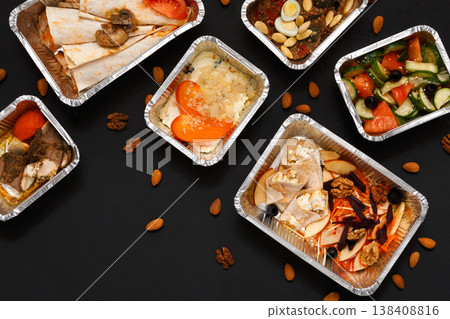 Healthy restaurant food delivery background with copy space. Foil containers with meals on black Healthy restaurant food delivery background with copy space. Foil containers with meals on black 138408816