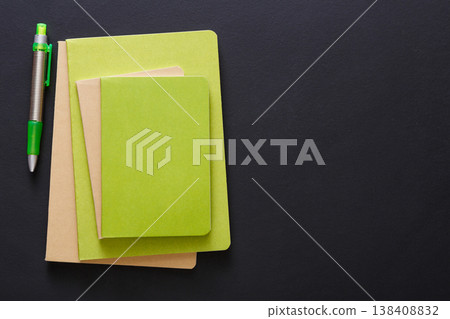 Stylish mockup with set of green notebooks and pen on black background with copy space, flat lay, concept of start-up and stationery supplies Stylish mockup with set of green notebooks and pen on black background with copy space, flat lay, concept of start-up and stationery supplies 138408832