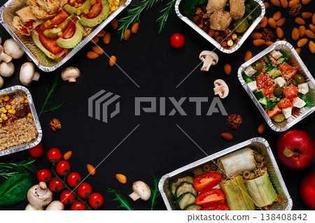 Healthy restaurant food delivery background with copy space. Mockup for menu, foil containers with meals on black Healthy restaurant food delivery background with copy space. Mockup for menu, foil containers with meals on black 138408842