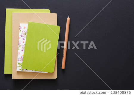 Stylish mockup with set of colorful notebooks and pencil on black background with copy space, flat lay, concept of start-up and stationery supplies Stylish mockup with set of colorful notebooks and pencil on black background with copy space, flat lay, concept of start-up and stationery supplies 138408876