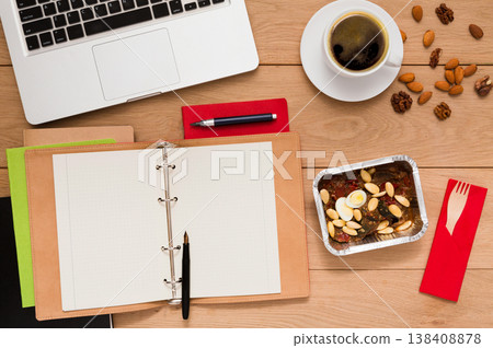 Healthy food delivery. Lunch box with diet meal on workplace, flat lay of wooden desktop with foiled container Healthy food delivery. Lunch box with diet meal on workplace, flat lay of wooden desktop with foiled container 138408878