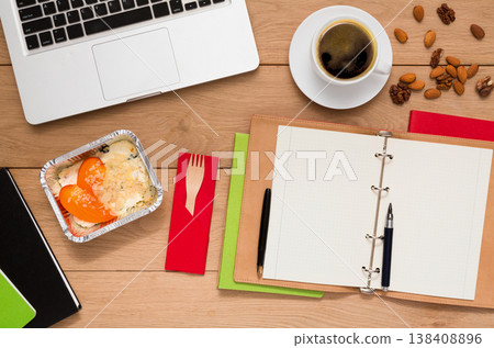 Healthy lunch at workplace. Foil box with diet meal, flat lay of wooden desktop with foiled container, copy space Healthy lunch at workplace. Foil box with diet meal, flat lay of wooden desktop with foiled container, copy space 138408896