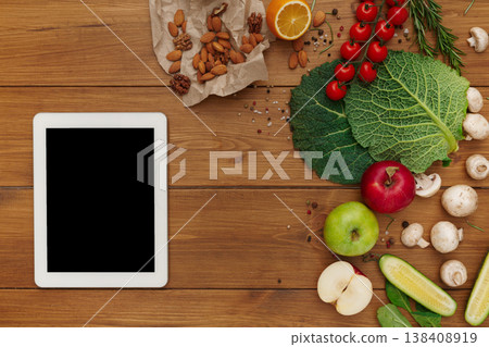 Healthy food, grocery online shopping, copy space on tablet screen. Fresh organic vegetables and fruits on wood table, top view, flat lay Healthy food, grocery online shopping, copy space on tablet screen. Fresh organic vegetables and fruits on wood table, top view, flat lay 138408919