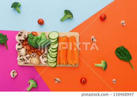 Vegetables on colorful abstract background. Healthy eating and diet. Cut raw vegetables on wooden board, copy space. Ingredients for salad or soup - mushroom, cherry tomato, broccoli, cucumber, carrot Vegetables on colorful abstract background. Healthy eating and diet. Cut raw vegetables on wooden board, copy space. Ingredients for salad or soup - mushroom, cherry tomato, broccoli, cucumber, carrot 138408947