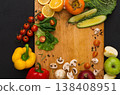 Cooking healthy vegetarian food background. Frame of fresh organic vegetables on black. Natural food and wooden cutting board with copy space. 138408951