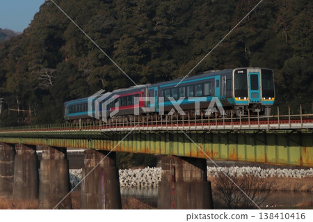 A JR Shikoku 2000 series diesel railcar, the Limited Express Uwajima, crossing the scenic Hijikawa River on the Yosan Line (photographed on February 21, 2026). A JR Shikoku 2000 series diesel railcar, the Limited Express Uwajima, crossing the scenic Hijikawa River on the Yosan Line (photographed on February 21, 2026). 138410416