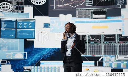 Business specialist doing strategy planning over telephone call, reviewing performance metrics. Manager using mobile phone to talk with business partner, evaluating annual report data, camera A 138410615
