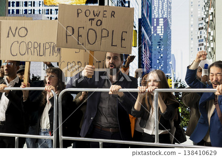 Activists marching together in political protest against corruption and misconduct, raising banners and signs to demand justice and reform. Dissatisfaction and public awareness in a rally. Activists marching together in political protest against corruption and misconduct, raising banners and signs to demand justice and reform. Dissatisfaction and public awareness in a rally. 138410629