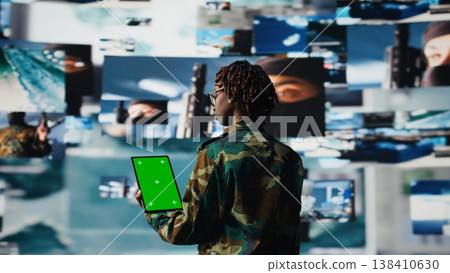 Soldier providing combat support using reconnaissance feeds on green screen mockup tablet. Intelligence agency expert uses battlefield communication network on chroma key device, camera A Soldier providing combat support using reconnaissance feeds on green screen mockup tablet. Intelligence agency expert uses battlefield communication network on chroma key device, camera A 138410630