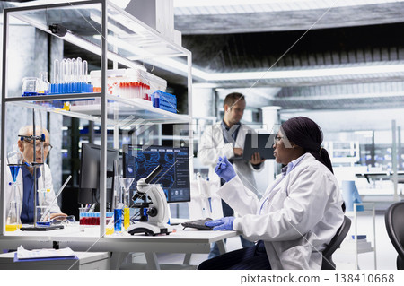 Woman scientist conducts research in biotechnology with compound samples, working on medical science in a laboratory. Reflecting advanced laboratory methods and medical discovery. 138410668