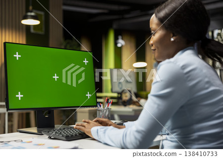 Green screen on computer monitor with black general director ensuring success, working in office after hours. Brainstorming solutions for development with a fruitful growth vision. 138410733