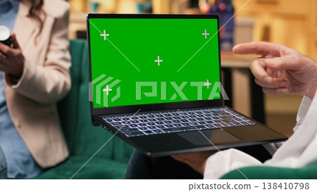 Green screen laptop with senior doctor recommending pills and vitamins as treatment used for recovery and wellbeing, private healthcare insurance. Woman medic consulting old man. 138410798