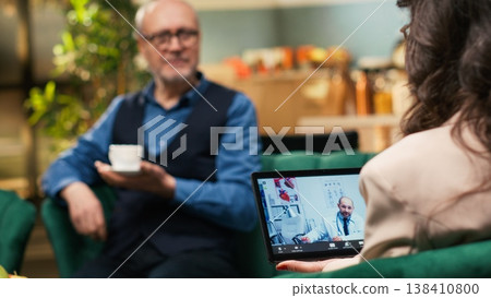 Aged woman receiving remote healthcare through video call with medic, asking about pills dosage and administration on tablet. Teleconsultation conference with medical aid and support at home. Aged woman receiving remote healthcare through video call with medic, asking about pills dosage and administration on tablet. Teleconsultation conference with medical aid and support at home. 138410800