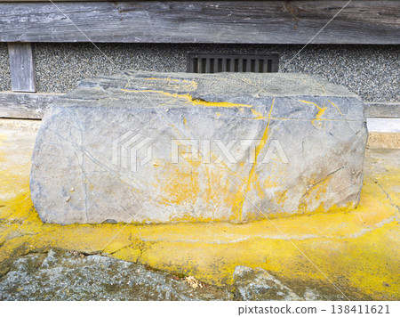 一塊長滿青苔的石頭,訴說著時間的流逝,雄偉地矗立在一座古老的農舍裡。 一塊長滿青苔的石頭,訴說著時間的流逝,雄偉地矗立在一座古老的農舍裡。 138411621