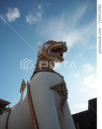 Mythical lion statue temple guardian thai sculpture golden ornament blue sky religious art cultural heritage spiritual symbol 138412092