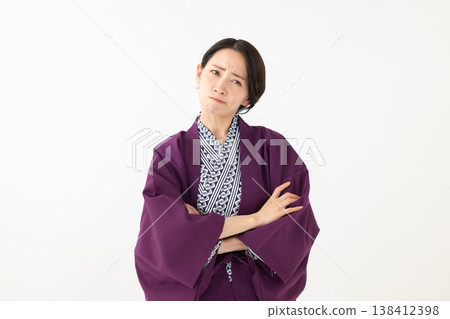 A middle-aged woman thinking while wearing a yukata A middle-aged woman thinking while wearing a yukata 138412398