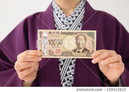 身穿浴衣的女子，手邊有鈔票，其中一張面額10,000日圓。 138412612