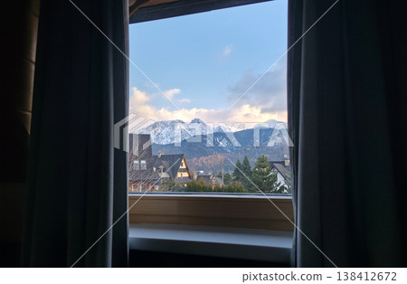 View of the Tatra Mountains and Mount Giewont covered with snow from the apartment window. Traveling to the Polish mountains in spring. High quality photo View of the Tatra Mountains and Mount Giewont covered with snow from the apartment window. Traveling to the Polish mountains in spring. High quality photo 138412672