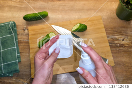 A woman is treating a knife cut on her finger in close-up against the background of a cutting board, cucumbers, and a knife in the kitchen. High quality photo A woman is treating a knife cut on her finger in close-up against the background of a cutting board, cucumbers, and a knife in the kitchen. High quality photo 138412686