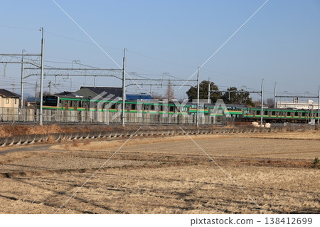 An eastbound JR Utsunomiya Line train running through a rural area. 138412699