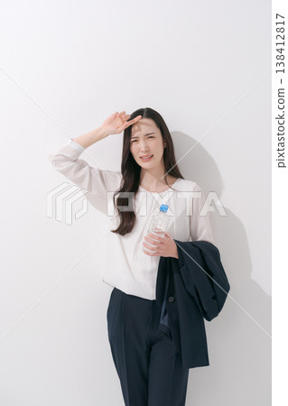 一張女性在炎熱夏季身穿職業套裝工作的照片。 138412817