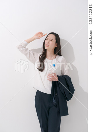 一張女性在炎熱夏季身穿職業套裝工作的照片。 138412818